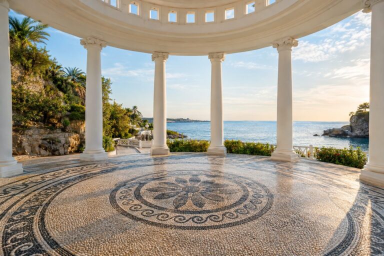 Witte rotonde van Kallithea Springs met elegante zuilen en een zwart-witte kiezelmozaïekvloer.