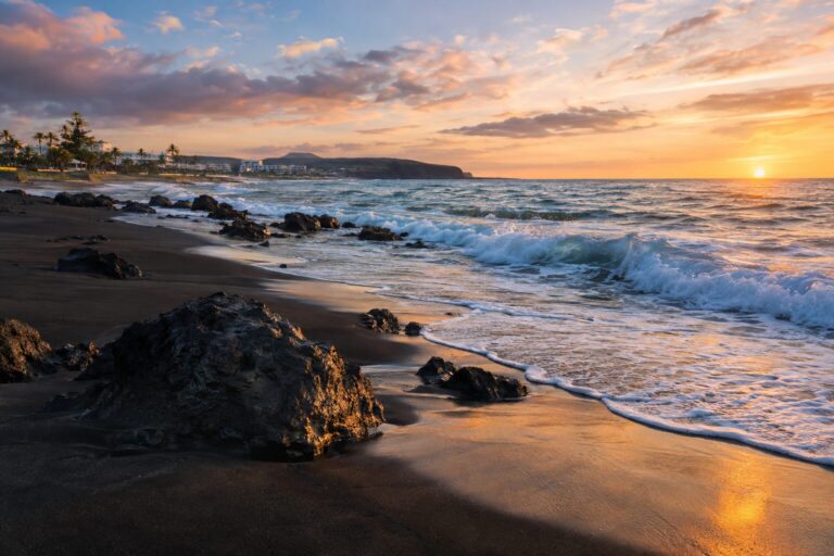 Donker vulkanisch zand en Atlantische golven op Playa de San Agustín op Gran Canaria
